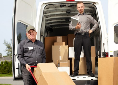 Professional movers loading household items into a truck